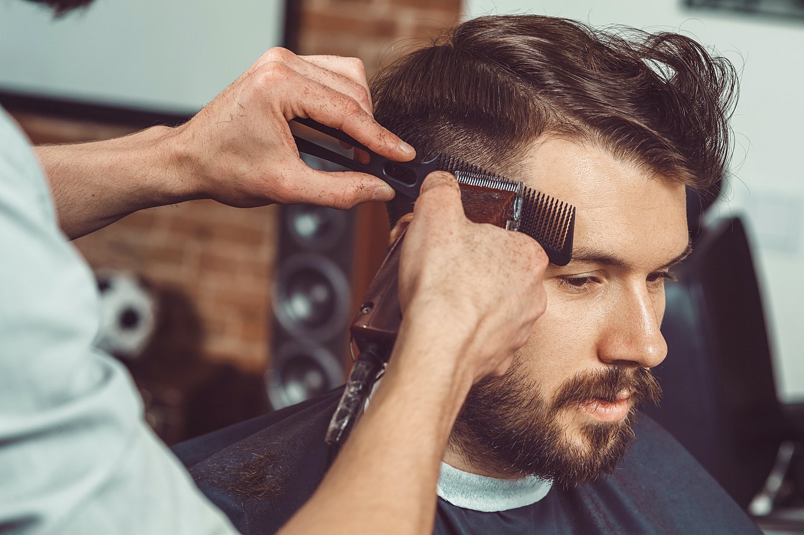 the-hands-of-young-barber-making-haircut-to-attractive-man-in-barbershop.jpg
